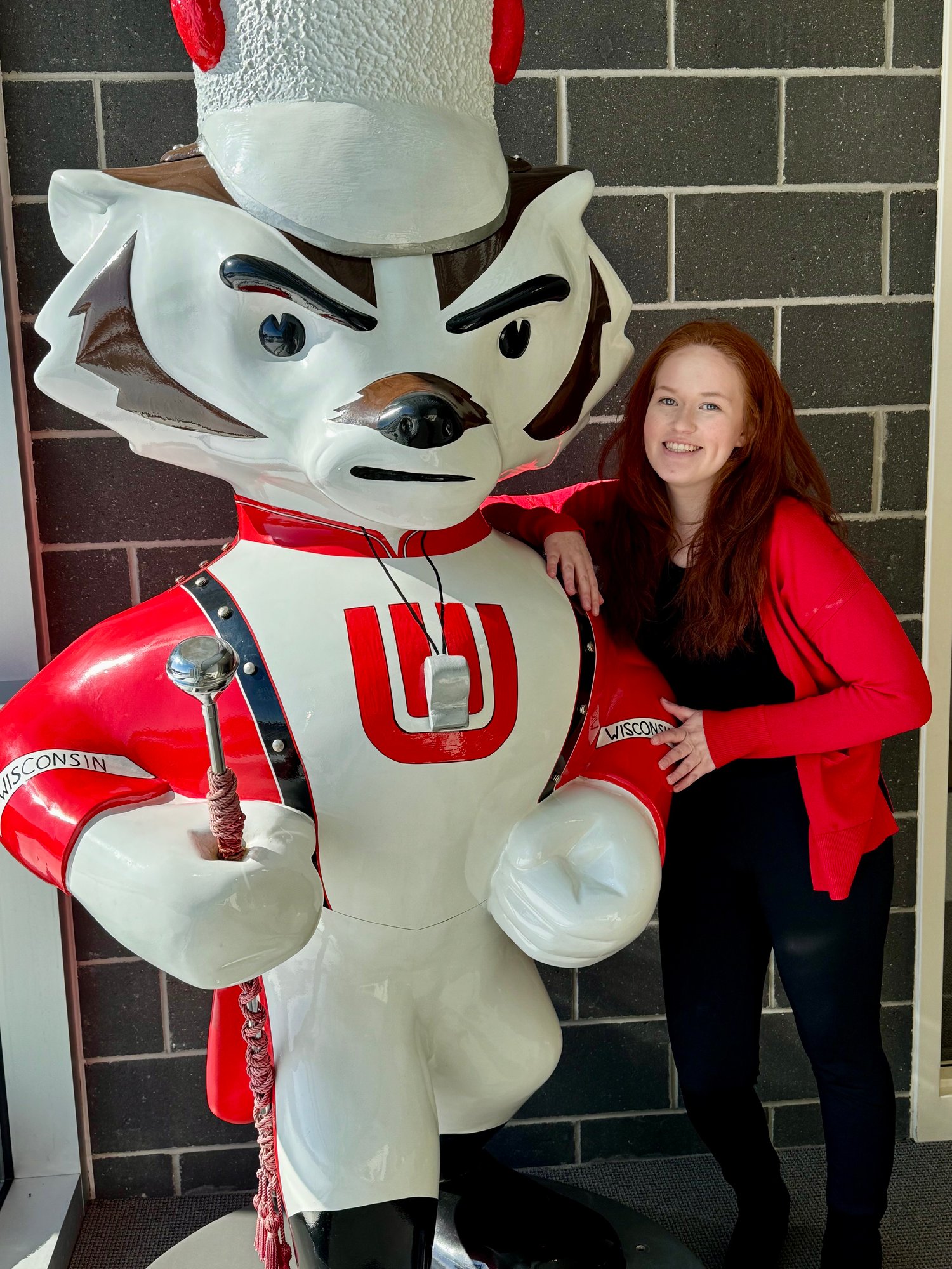 Stephanie Schoone standing next to bucky badger statue